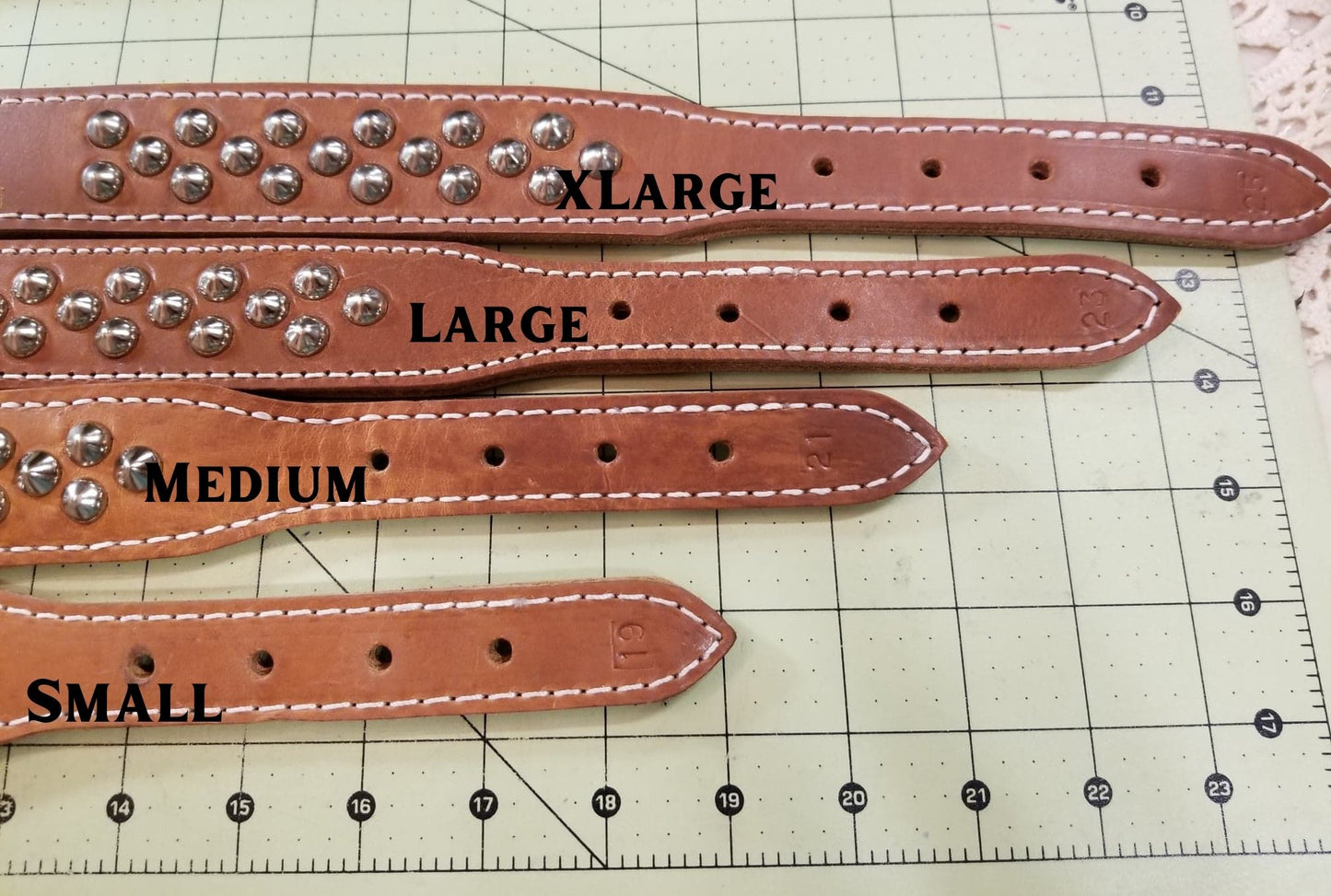 Brown leather dog collar size guide showing hole placement for Small, Medium, Large and XLarge