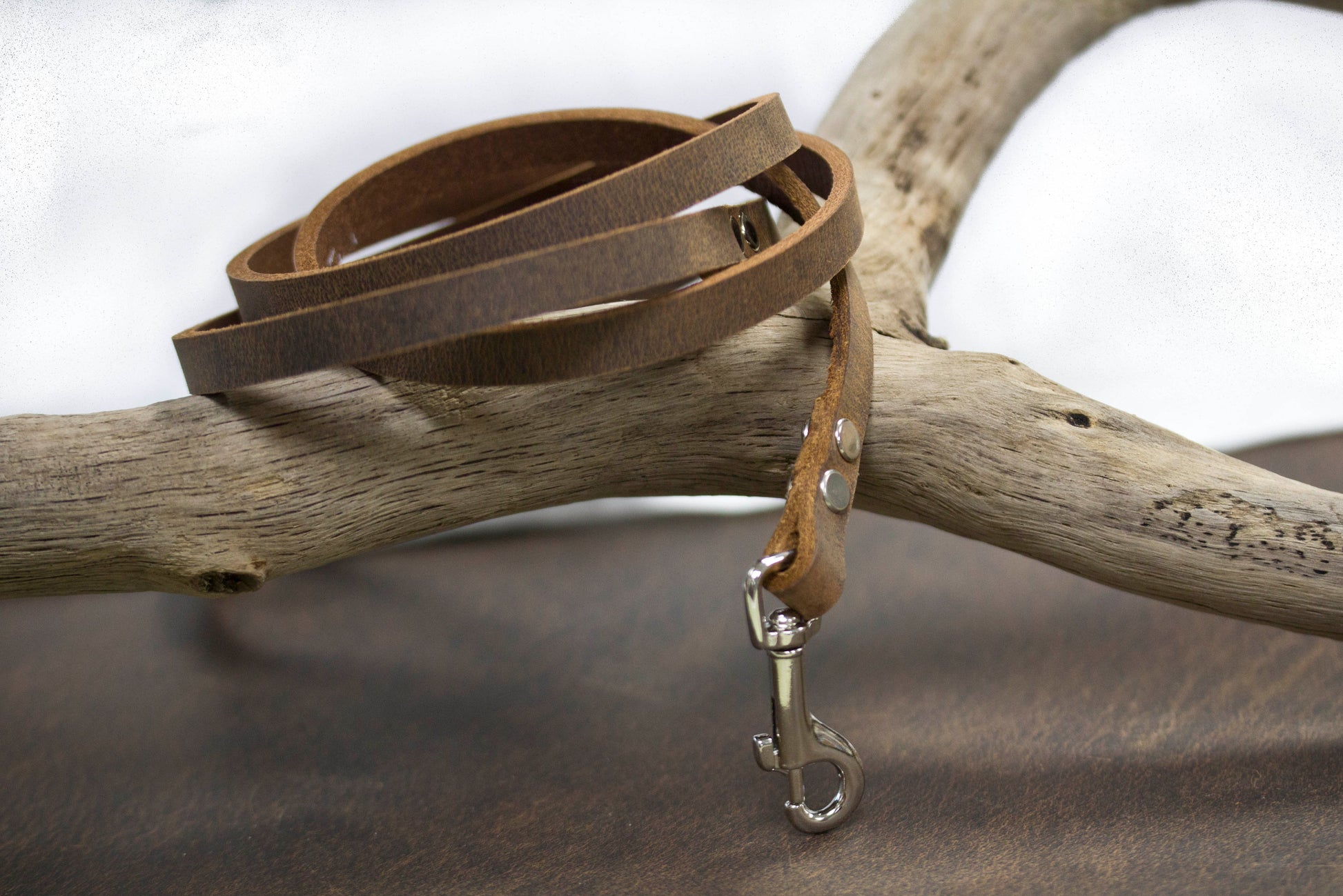 Heritage leather dog leash coiled on vintage metal frame - premium natural leather made in USA